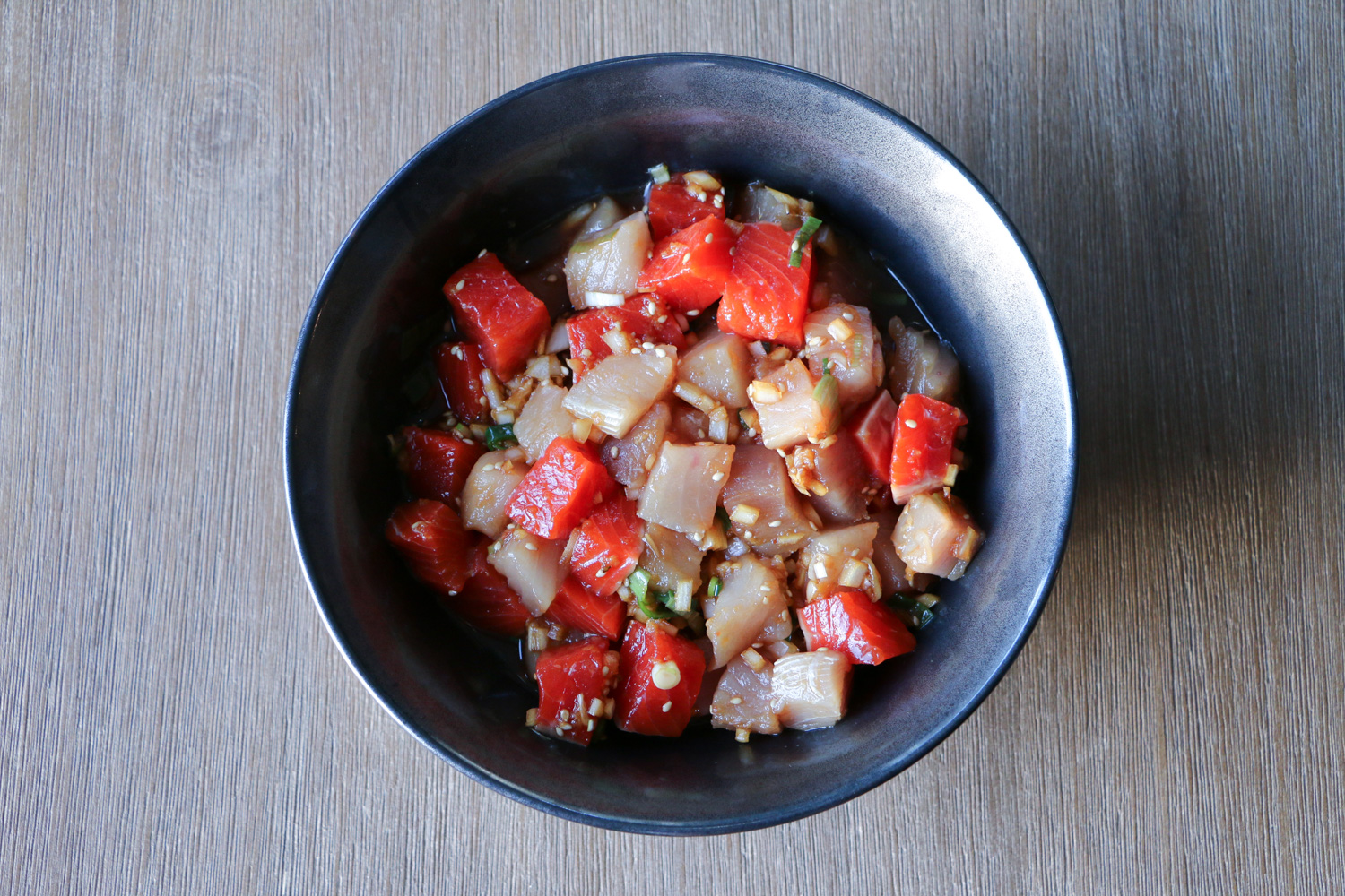 Fresh tuna and salmon marinating in shoyu poke marinade