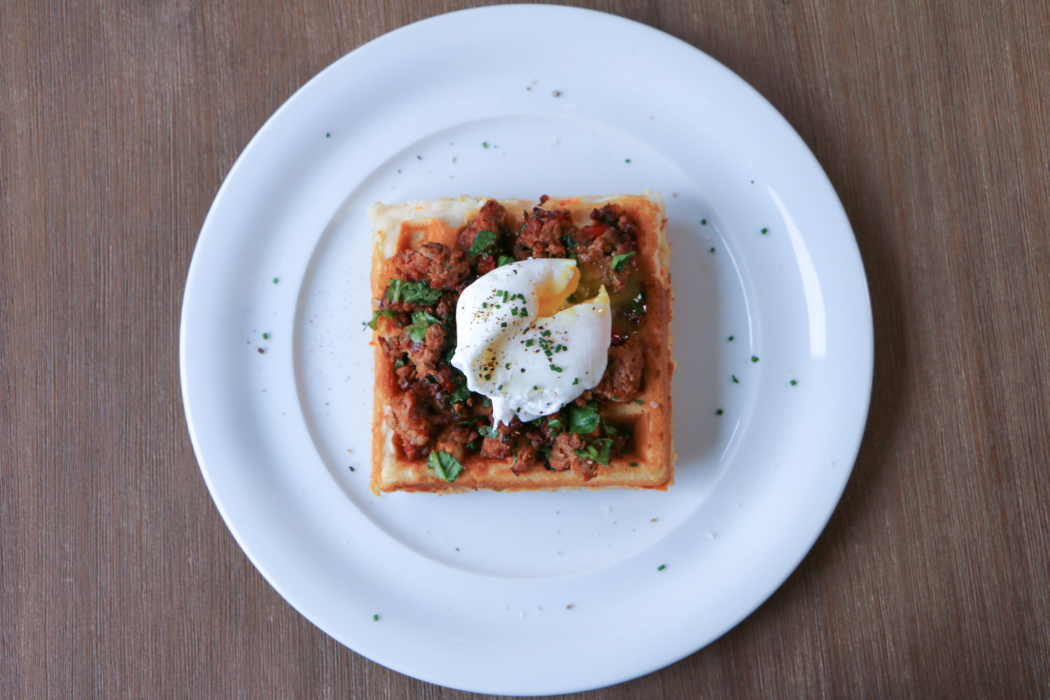 Breakfast Waffles with Italian Sausage and Poached Egg and Maple Syrup