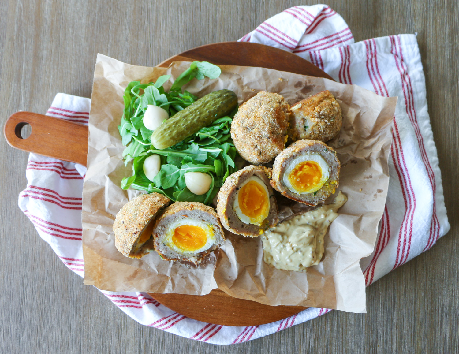 Scotch Eggs with pickles and arugula