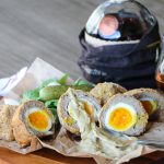 Scotch eggs with pickles and a drink of Scotch