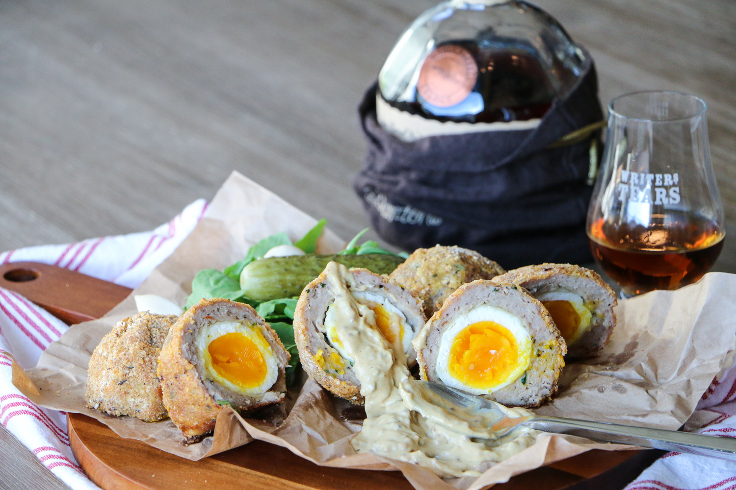 Scotch eggs with pickles and a drink of Scotch
